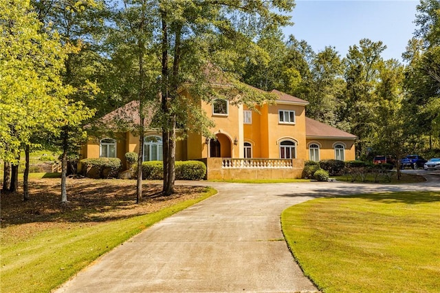 56 Peachwood Dr, Tallassee, AL 36078 - mediterranean / spanish-style house with concrete driveway, stucco siding, and a front yard
