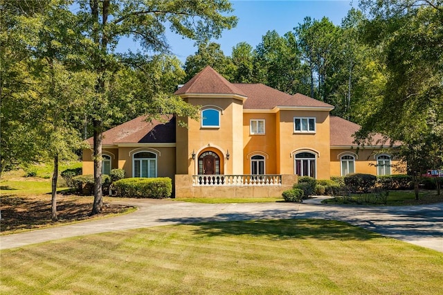 56 Peachwood Dr, Tallassee, AL 36078 - mediterranean / spanish-style home featuring stucco siding, a front yard, roof with shingles, and driveway