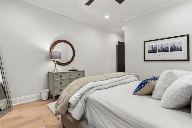 bedroom featuring ceiling fan, crown molding, and light hardwood / wood-style flooring
