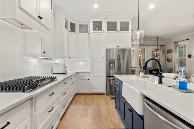 kitchen featuring light stone countertops, white cabinets, hanging light fixtures, and appliances with stainless steel finishes
