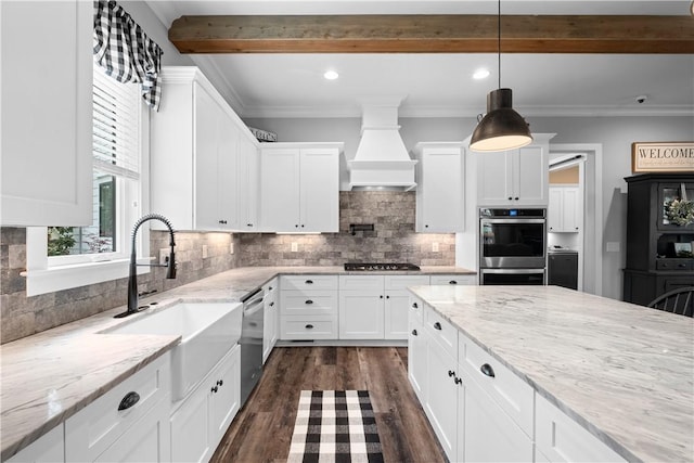 kitchen featuring custom range hood, dark wood-style flooring, stainless steel appliances, a sink, and white cabinets