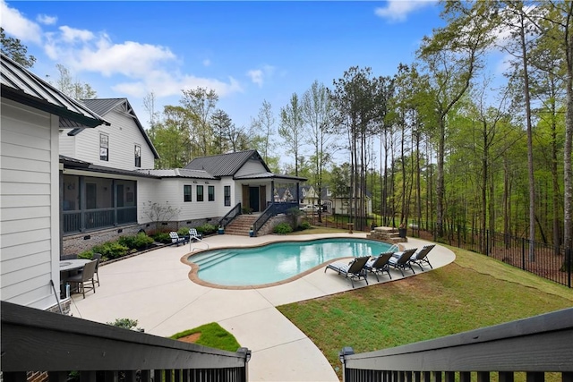 view of swimming pool with a sunroom, fence, a patio, a fenced in pool, and a lawn