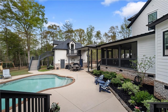 view of pool with a sunroom, fence, stairs, a fenced in pool, and a patio area