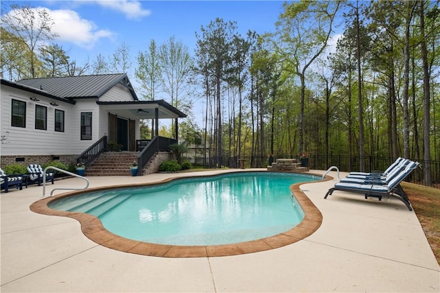 view of swimming pool with fence, a patio, a fenced in pool, stairway, and a ceiling fan