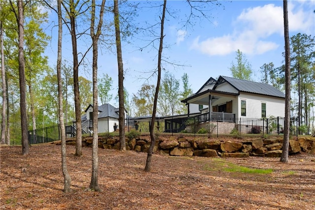 view of front of house with metal roof and fence