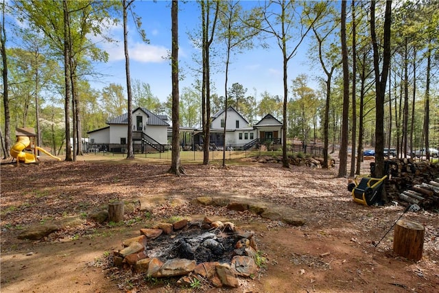 view of yard featuring an outdoor fire pit and fence
