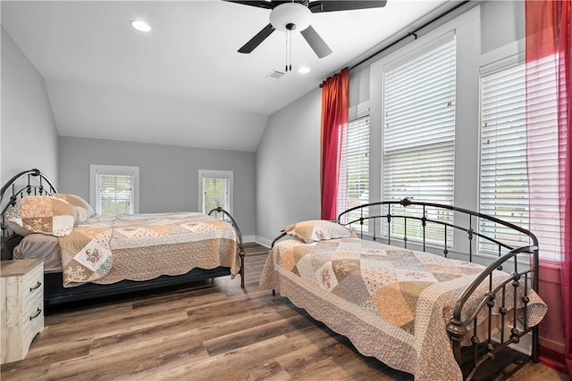 bedroom with vaulted ceiling, baseboards, ceiling fan, visible vents, and wood finished floors