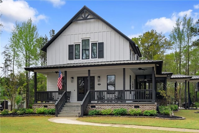 modern farmhouse with a front lawn, metal roof, covered porch, and board and batten siding