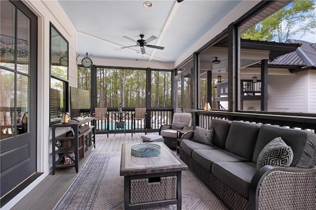 sunroom / solarium with outdoor dining area, a ceiling fan, and an outdoor hangout area
