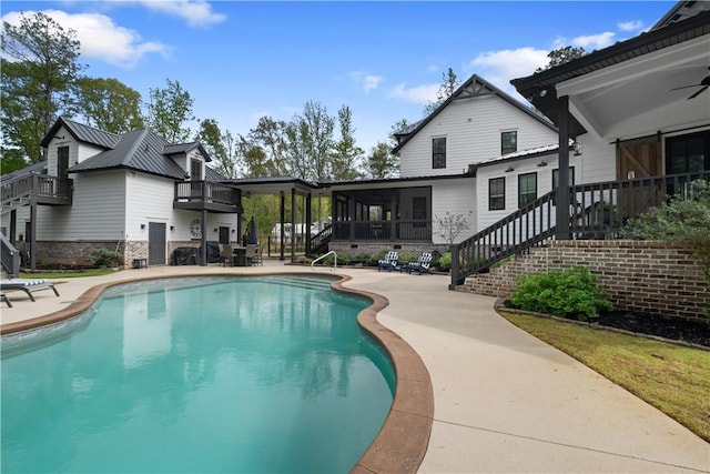 view of swimming pool featuring stairs, a sunroom, a patio, and a fenced in pool