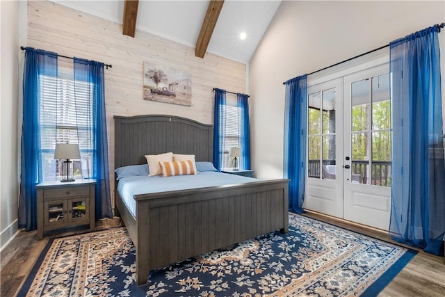 bedroom featuring access to exterior, lofted ceiling with beams, wood finished floors, and french doors