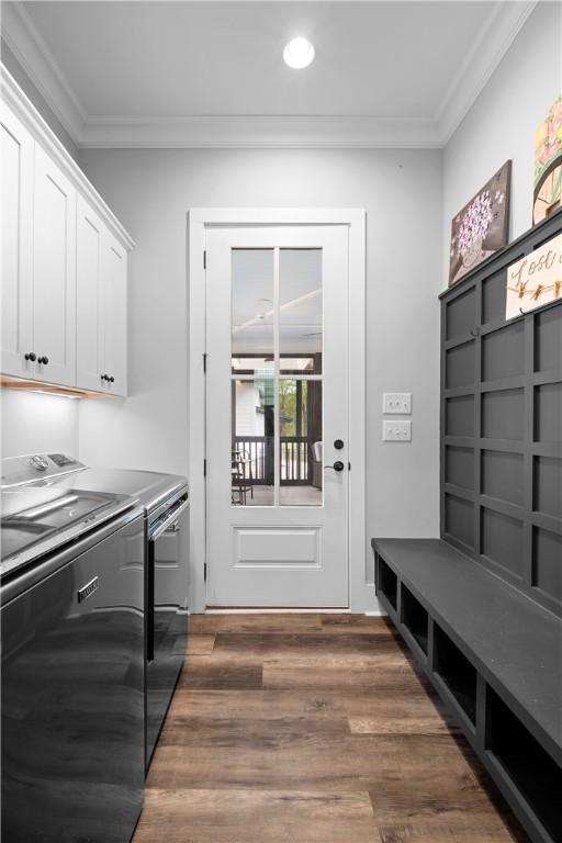 clothes washing area with cabinet space, ornamental molding, independent washer and dryer, and dark wood-style floors