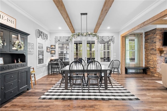 dining room with ornamental molding, wood finished floors, and beamed ceiling