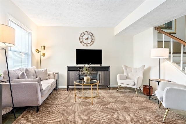 carpeted living room featuring a healthy amount of sunlight and a textured ceiling