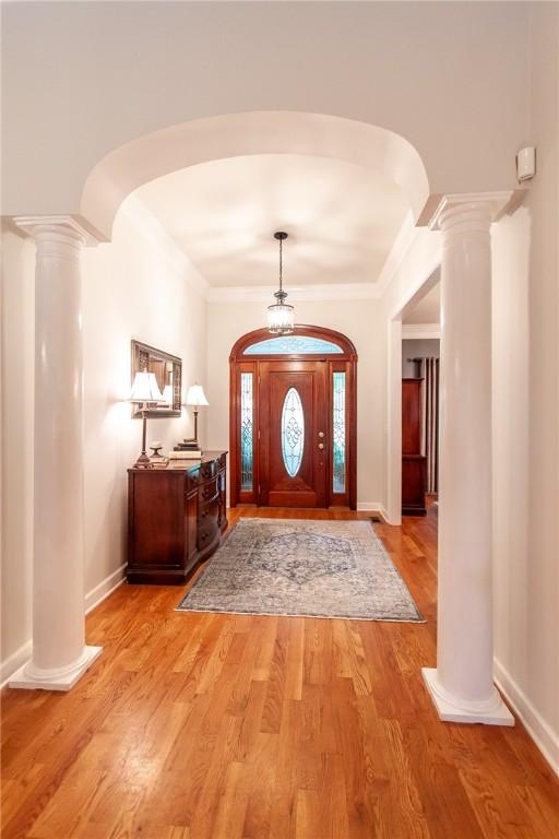 1849 Stoneridge Dr, Auburn, AL 36830 - entryway with ornate columns, arched walkways, crown molding, light wood-style floors, and baseboards