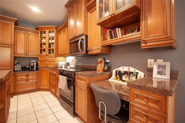 1849 Stoneridge Dr, Auburn, AL 36830 - kitchen with black range with electric stovetop, stainless steel microwave, brown cabinets, and light tile patterned floors