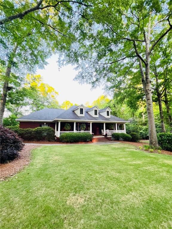 farmhouse inspired home featuring a porch and a front yard