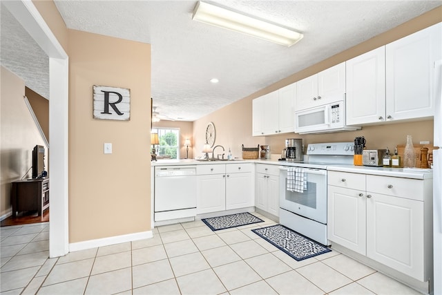 1477 N Donahue Dr Unit 2701, Auburn, AL 36832 - kitchen featuring white appliances, a textured ceiling, light countertops, white cabinetry, and light tile patterned flooring