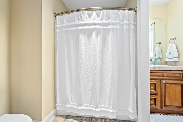 bathroom featuring vanity, baseboards, a shower with curtain, and toilet