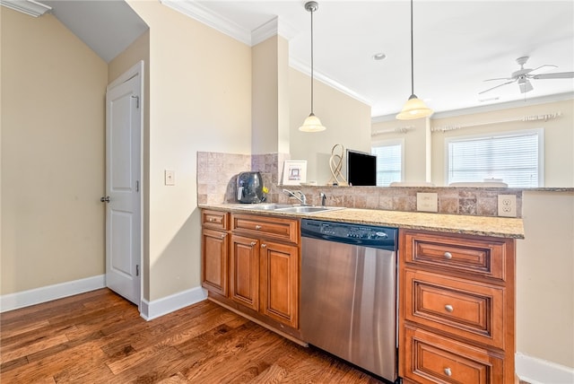 kitchen featuring brown cabinets, a sink, dishwasher, a peninsula, and ornamental molding