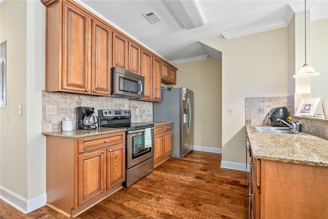 kitchen with crown molding, appliances with stainless steel finishes, decorative backsplash, and a sink