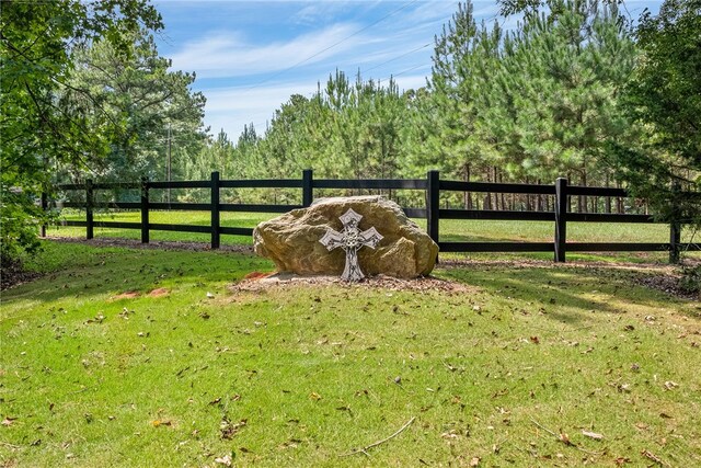 view of gate with a lawn