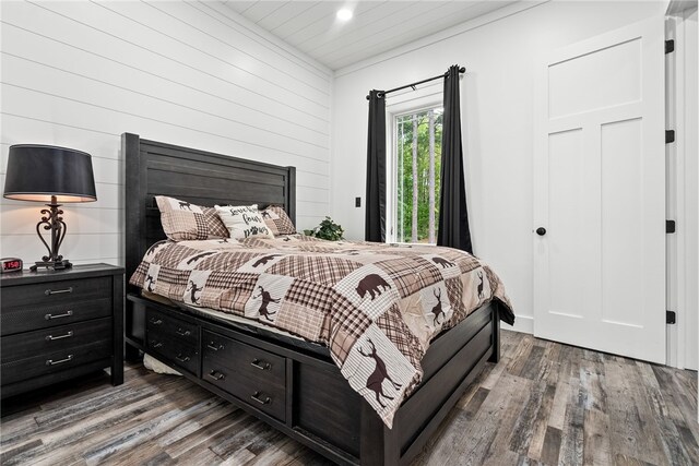 bedroom with wood walls and wood-type flooring