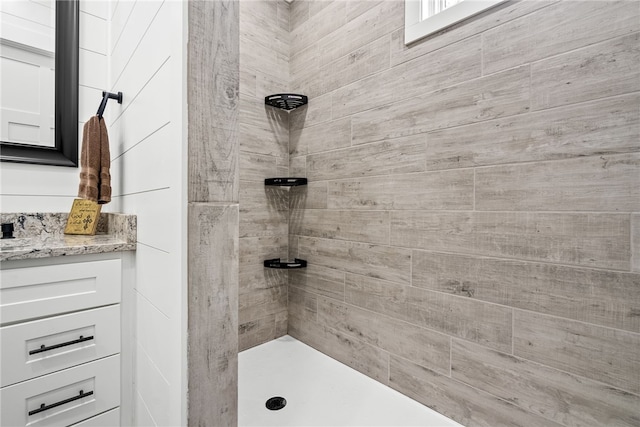 bathroom with vanity and a tile shower