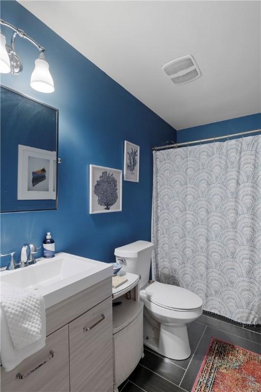 bathroom featuring tile patterned floors, vanity, and toilet