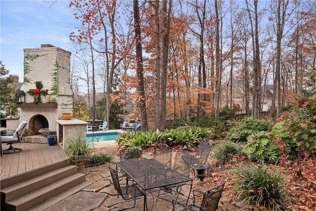 view of patio with a swimming pool side deck and an outdoor stone fireplace