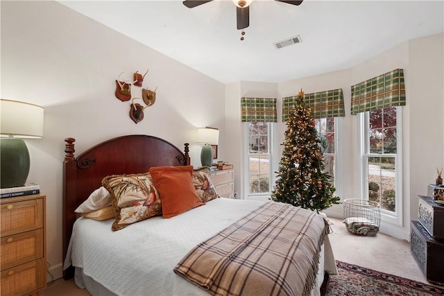 carpeted bedroom with multiple windows and ceiling fan