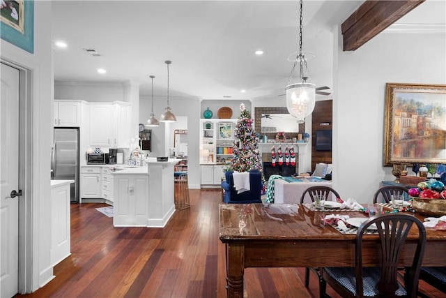 dining area featuring beam ceiling, sink, dark hardwood / wood-style flooring, and ornamental molding