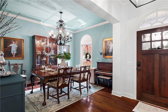 dining room with a chandelier, ornamental molding, dark hardwood / wood-style floors, and a healthy amount of sunlight