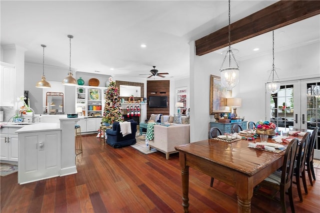 dining room with dark hardwood / wood-style flooring, ceiling fan, crown molding, sink, and a fireplace