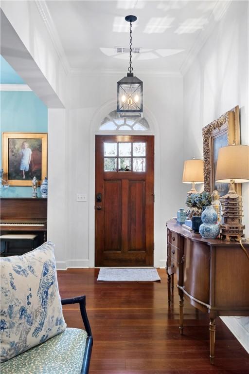 entrance foyer with crown molding and dark wood-type flooring