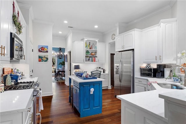 kitchen with a center island, stainless steel appliances, white cabinetry, and light stone counters