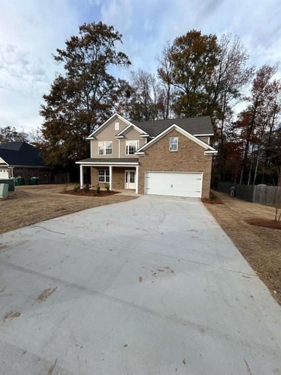 traditional home with concrete driveway, a garage, and brick siding
