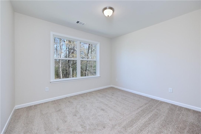 unfurnished room featuring carpet flooring, visible vents, and baseboards