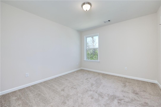 spare room with visible vents, baseboards, and carpet flooring