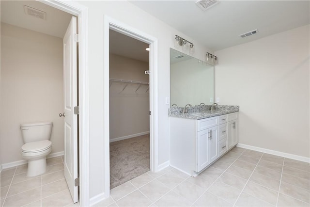 full bath with a sink, visible vents, and a spacious closet