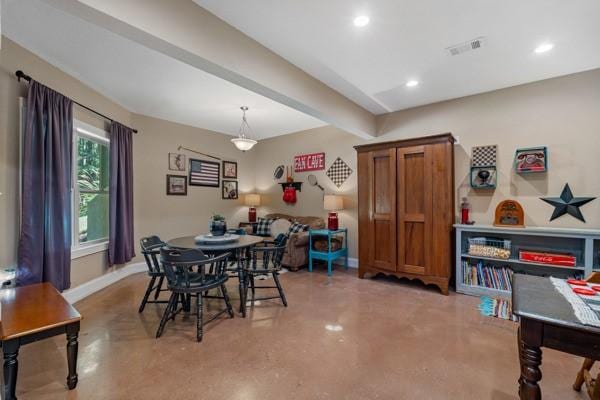 dining room featuring concrete flooring and beam ceiling