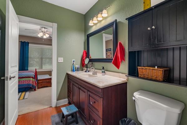 bathroom featuring ceiling fan, hardwood / wood-style flooring, vanity, and toilet