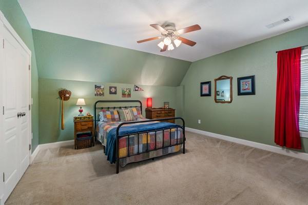 bedroom with light carpet, ceiling fan, and lofted ceiling