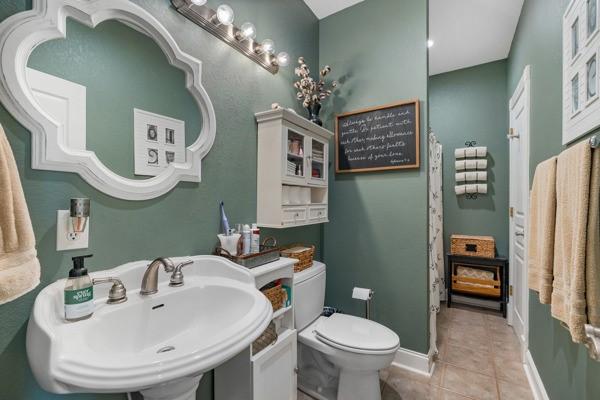 bathroom featuring toilet, tile patterned flooring, and sink