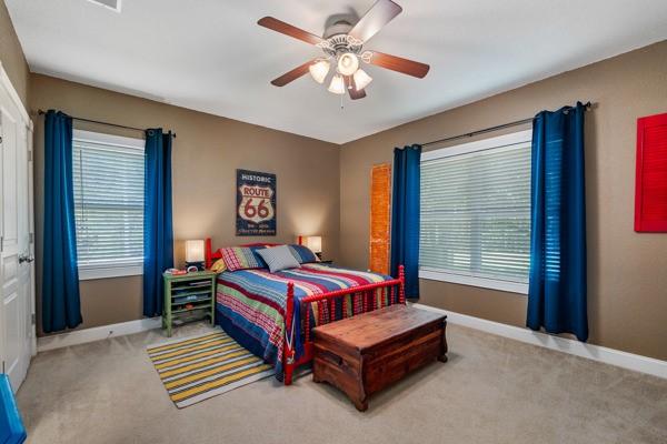 bedroom featuring light colored carpet and ceiling fan