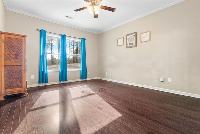 spare room featuring dark wood-style floors, ornamental molding, and visible vents