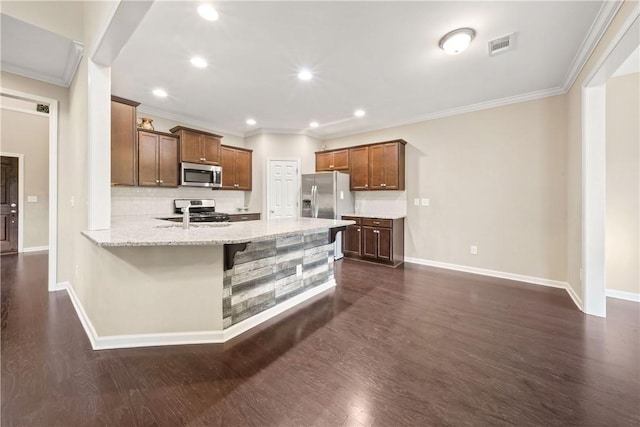 2133 W Farmville Rd W, Auburn, AL 36879 - kitchen with appliances with stainless steel finishes, crown molding, baseboards, a peninsula, and dark wood-style flooring
