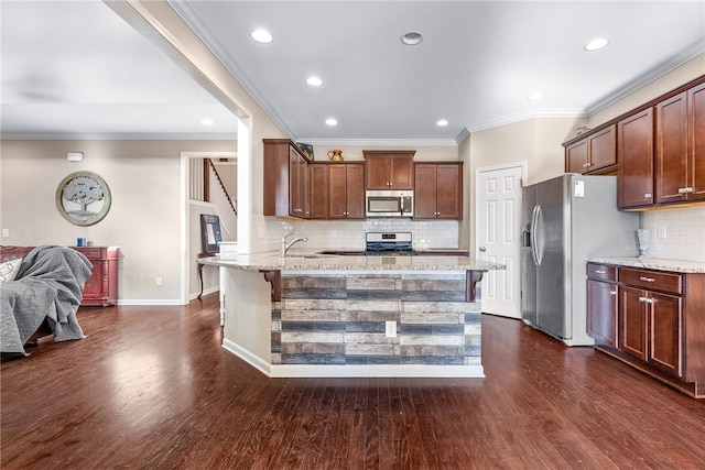 kitchen featuring light stone counters, dark wood finished floors, stainless steel appliances, open floor plan, and a kitchen breakfast bar