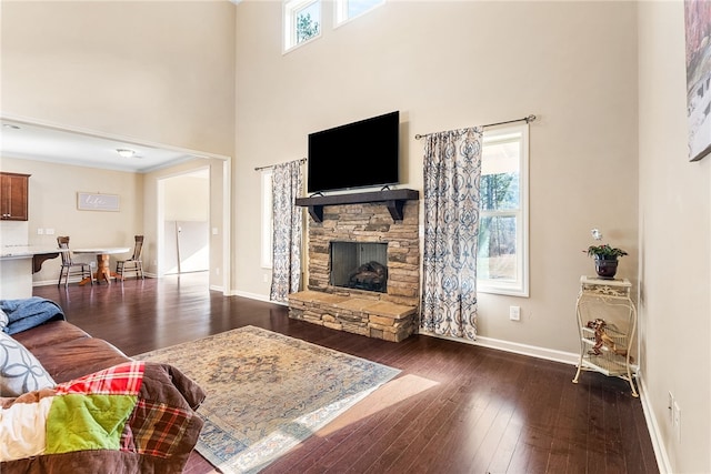 living room featuring a healthy amount of sunlight, baseboards, and dark wood finished floors