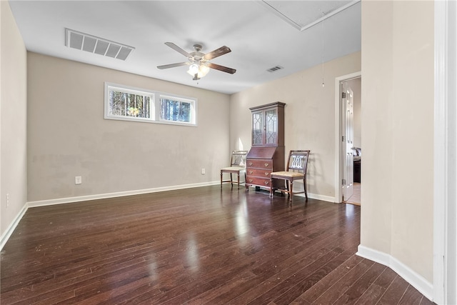 living area with baseboards, attic access, visible vents, and dark wood-style flooring